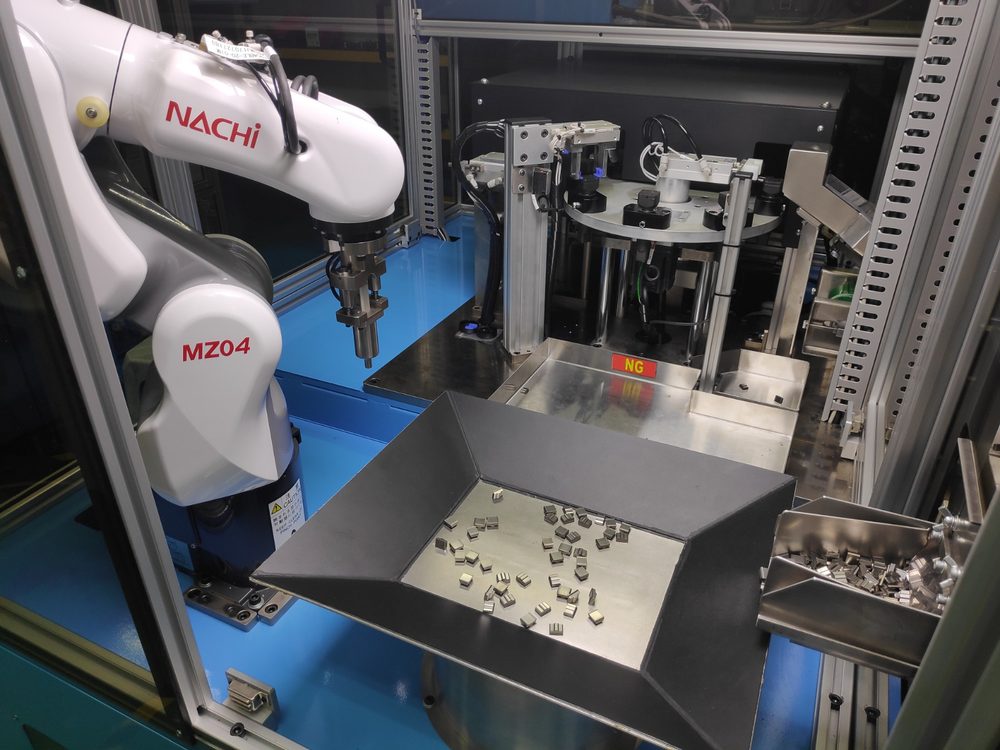 Robot vision pick-up and inspection cell built by Xtrotech, with six-axis robot, indexing table and automatic NG reject chute